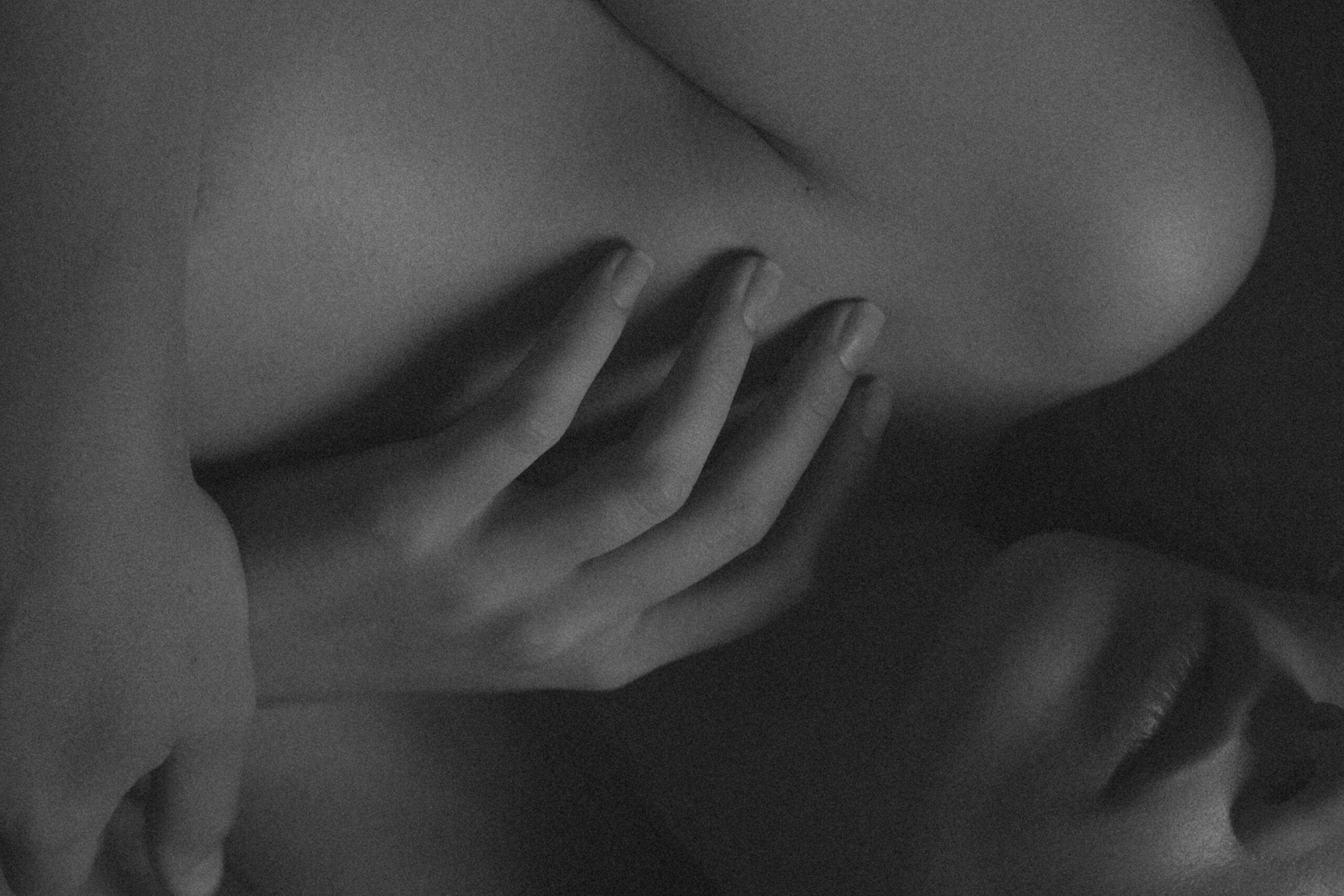 mano tocando el cuerpo desnudo en blanco y negro