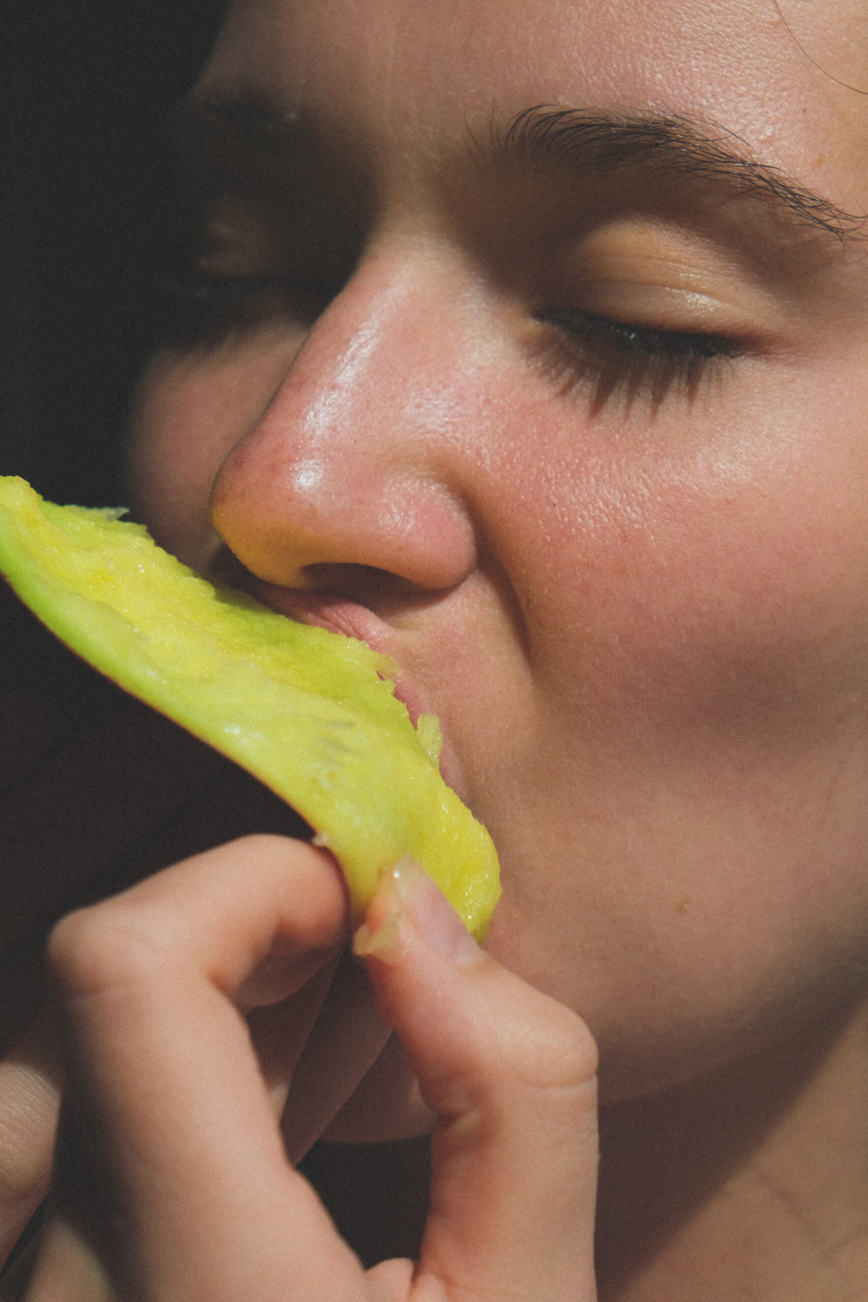 detalle cara mujer comiendo fruta